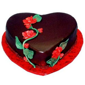 torta a forma di cuore al cioccolato con rosa rossa come decorazione