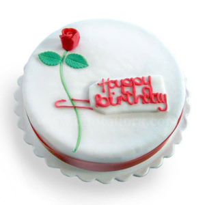 Torta glassata in bianco Buon Compleanno con una rosa decorata in marzapane